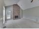 Bright living room featuring vaulted ceilings, a cozy brick fireplace, and a back door at 7053 Colita More Nw Ct, Indianapolis, IN 46254
