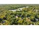 Aerial view of tree-lined neighborhood and the lake, surrounded by green and yellow trees at 7126 Nile Ridge Ct, Indianapolis, IN 46236