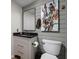Modern bathroom featuring wood paneled wall, dark countertop, and decorative floral painting at 7126 Nile Ridge Ct, Indianapolis, IN 46236