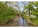 A gently flowing creek reflects the surrounding lush greenery and trees at 7126 Nile Ridge Ct, Indianapolis, IN 46236