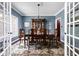 Formal dining room with blue walls, hardwood floor, chandelier, and french doors leading to another room at 7126 Nile Ridge Ct, Indianapolis, IN 46236
