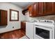 Spacious laundry room boasts hardwood floors, overhead cabinets, sink, and modern washer and dryer at 7126 Nile Ridge Ct, Indianapolis, IN 46236