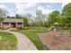 Playground area featuring swings, slide, and a small picnic area surrounded by green grass and trees at 7126 Nile Ridge Ct, Indianapolis, IN 46236