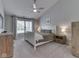 Spacious bedroom with neutral tones, a ceiling fan, and a large window at 7203 Sycamore Run Dr, Indianapolis, IN 46237