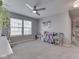 Bright bedroom with a ceiling fan, many windows, and decorated with books, toys, and dress-up clothes at 7203 Sycamore Run Dr, Indianapolis, IN 46237