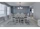 Stylish dining room featuring a modern chandelier, paneled accent wall, and elegant white dining set at 7203 Sycamore Run Dr, Indianapolis, IN 46237
