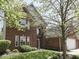 Charming red brick two-story home featuring a well-manicured lawn and mature shade trees at 7203 Sycamore Run Dr, Indianapolis, IN 46237
