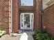 Inviting front entrance with a modern glass door, stylish welcome sign, and decorative potted plants at 7203 Sycamore Run Dr, Indianapolis, IN 46237