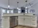 Open concept kitchen with a large island featuring white cabinets, stainless steel appliances and modern pendant lighting at 7203 Sycamore Run Dr, Indianapolis, IN 46237