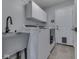 Bright laundry room featuring a modern sink, white washer and dryer, and a convenient exterior door at 7203 Sycamore Run Dr, Indianapolis, IN 46237
