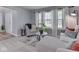Comfortable living room featuring neutral tones, large windows with sheer curtains, and stylish furnishings at 7203 Sycamore Run Dr, Indianapolis, IN 46237
