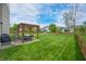 Expansive backyard featuring a pergola with dining set, lush lawn, and mature trees at 7319 Hartington Pl, Indianapolis, IN 46259