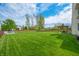 Large backyard featuring a spacious lawn, mature trees, and outdoor living areas at 7319 Hartington Pl, Indianapolis, IN 46259