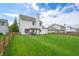 Spacious fenced backyard featuring a lush lawn, mature trees, and outdoor seating area at 7319 Hartington Pl, Indianapolis, IN 46259