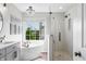 Luxurious bathroom with a freestanding tub, glass shower, modern finishes, and a large window at 7319 Hartington Pl, Indianapolis, IN 46259
