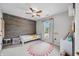 Charming bedroom with wood paneling, a ceiling fan, a window and a playful rug at 7319 Hartington Pl, Indianapolis, IN 46259