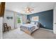 Comfortable bedroom with a ceiling fan, accent wall, and large window providing natural light at 7319 Hartington Pl, Indianapolis, IN 46259
