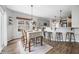 Well-lit dining area with a view into the kitchen featuring barstool seating and modern light fixtures at 7319 Hartington Pl, Indianapolis, IN 46259