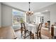 Dining room with modern chandelier, wood table and chairs, and open to other rooms at 7319 Hartington Pl, Indianapolis, IN 46259