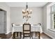 Dining room with modern chandelier, wood table and chairs, and view to the outdoors at 7319 Hartington Pl, Indianapolis, IN 46259