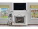Elegant fireplace with decorative tile and a white mantle, situated between bright windows at 7319 Hartington Pl, Indianapolis, IN 46259