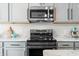 Modern kitchen featuring stainless steel appliances and updated countertop with a microwave, stove, and oven at 7319 Hartington Pl, Indianapolis, IN 46259