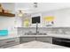Bright kitchen featuring a stainless steel double sink, marble countertops, and modern finishes at 7319 Hartington Pl, Indianapolis, IN 46259