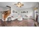 Inviting living room featuring a sectional sofa, ceiling fan, and staircase with wooden handrail at 7319 Hartington Pl, Indianapolis, IN 46259