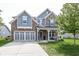 Charming two-story home boasts stone and gray siding, a well-manicured lawn, and an attached two-car garage at 755 Canberra Blvd, Westfield, IN 46074