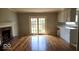 Spacious living room with hardwood floors, fireplace, and access to backyard via glass patio doors at 7629 Walton Dr, Indianapolis, IN 46214