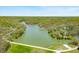Community aerial view shows long lake surrounded by trees and homes during spring season and blue sky at 8277 N Lasalle Rd, Morgantown, IN 46160