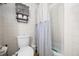 Bright bathroom featuring a toilet, tiled walls, and a shower with a curtain at 8277 N Lasalle Rd, Morgantown, IN 46160