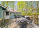 Expansive deck offering multiple seating arrangements and outdoor cooking facilities, framed by a tranquil wooded backdrop at 8277 N Lasalle Rd, Morgantown, IN 46160