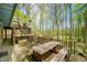 A spacious deck features a wooden picnic table and views of the surrounding lush trees and a wooden play structure at 8277 N Lasalle Rd, Morgantown, IN 46160
