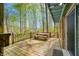 Expansive wooden deck offers a picnic table, outdoor seating, and scenic views of the surrounding lush green forest at 8277 N Lasalle Rd, Morgantown, IN 46160
