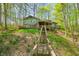 Multi-level deck wraps around the house nestled in a wooded setting, accessed by stairs from the hillside at 8277 N Lasalle Rd, Morgantown, IN 46160