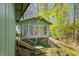 Charming home exterior showcases a screened porch, wooden staircase, and views of lush green trees and landscaping at 8277 N Lasalle Rd, Morgantown, IN 46160