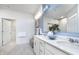 Well-lit bathroom with double vanity, quartz countertops, framed mirror, and open door to a walk-in closet at 8436 Paxton Dr, Brownsburg, IN 46112