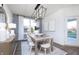 Dining room with a modern chandelier, a wooden table, and white chairs at 8436 Paxton Dr, Brownsburg, IN 46112