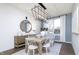 Bright dining area featuring a modern chandelier, a wooden table, and white chairs at 8436 Paxton Dr, Brownsburg, IN 46112