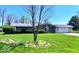 Ranch home with an attached garage has a large front lawn and landscaping at 8604 W Tulip Tree Dr, Muncie, IN 47304