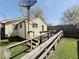The backyard features a wooden deck with ramp, grassy area, and partial fencing at 907 W 14Th St, Muncie, IN 47302