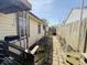 A view of the narrow side yard with a chain-link fence and a glimpse of the neighboring house at 907 W 14Th St, Muncie, IN 47302