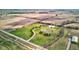 Aerial view of private estate with large pond, tree-lined driveway, and green space surrounded by agricultural fields at 9377 N 500 W, McCordsville, IN 46055