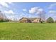 An exterior view of the ranch-style home with a well-manicured lawn under a partly cloudy blue sky at 9377 N 500 W, McCordsville, IN 46055
