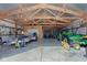 Garage with exposed rafters filled with tractors, trailers and other machinery at 9377 N 500 W, McCordsville, IN 46055
