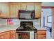 Well-lit kitchen with wooden cabinets, modern appliances, and vintage wall art at 9377 N 500 W, McCordsville, IN 46055