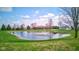 Scenic view of a home with a picturesque pond featuring a fountain and dock, set against a bright sky at 9377 N 500 W, McCordsville, IN 46055