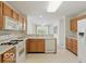 Kitchen showcasing wood cabinets, white appliances, and a breakfast bar at 1108 Nanwich Ct, Indianapolis, IN 46217
