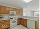 Well-lit kitchen with gas range, wood cabinets, and a view into the living room at 1108 Nanwich Ct, Indianapolis, IN 46217